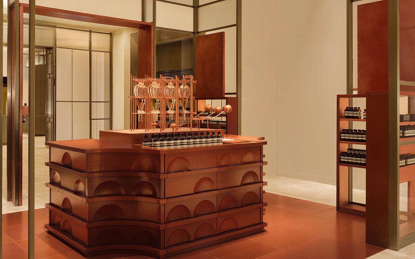 Side view of Aesop’s terracotta counter and fragrance displays at Harrods