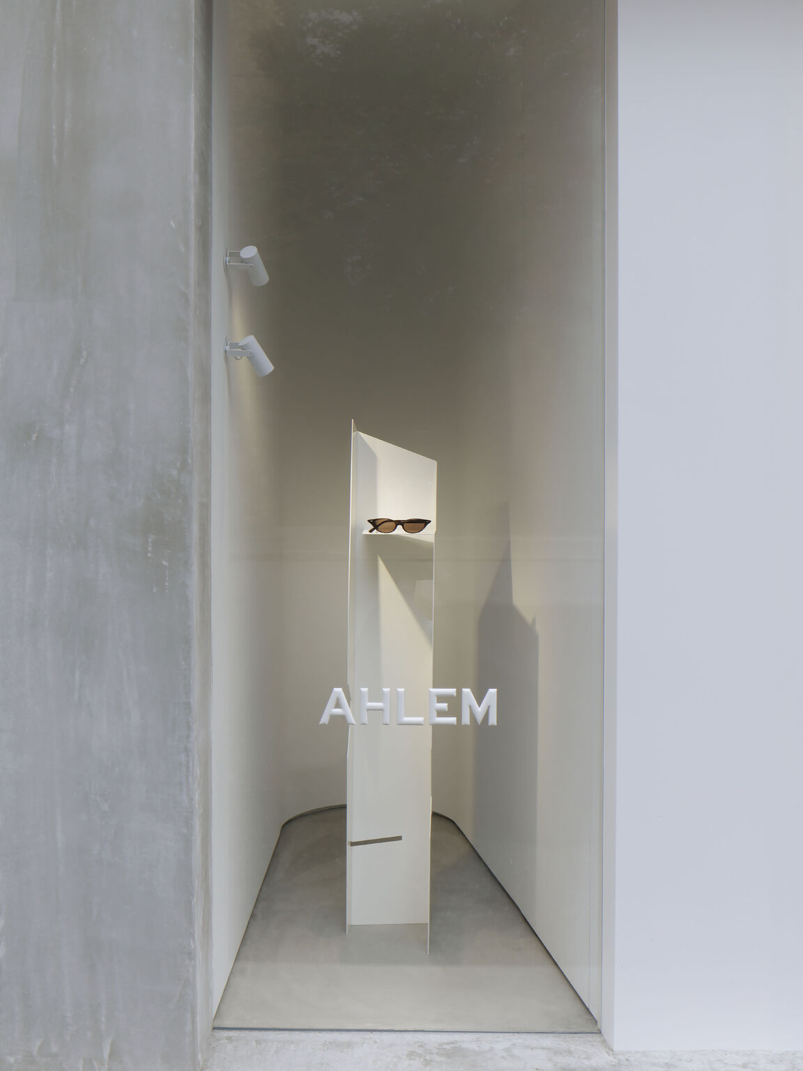 Sculptural eyewear pedestal inside AHLEM Tokyo