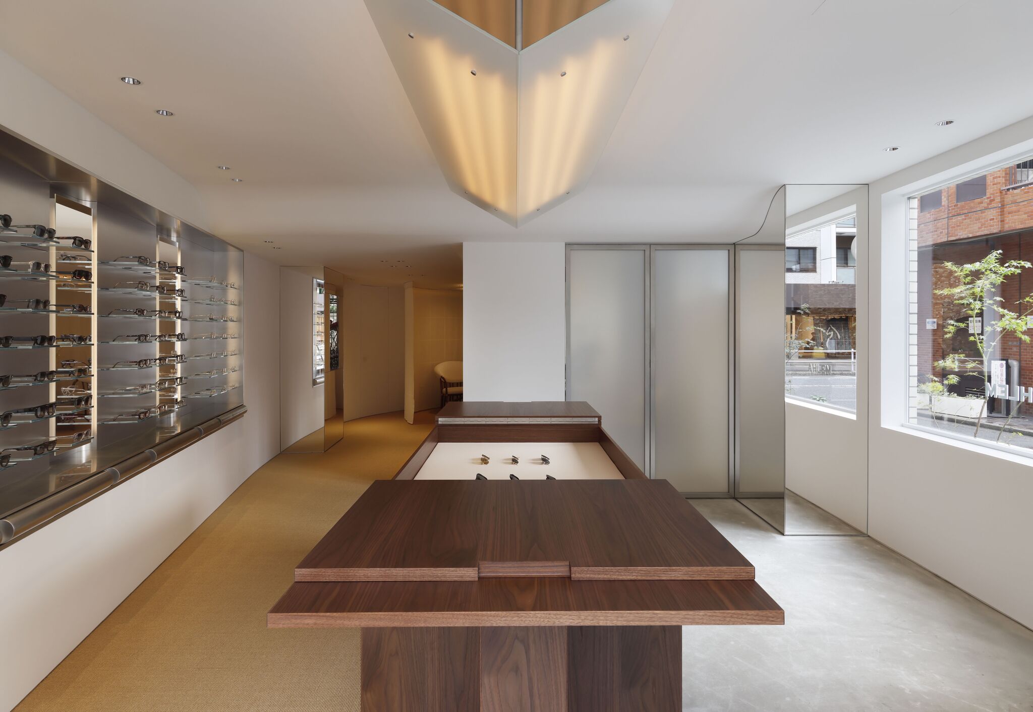 Wooden display tables and eyewear gallery at AHLEM Tokyo