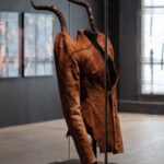 Alexander McQueen's horn-shouldered jacket from the Autumn Winter 1997 It's a Jungle Out There collection displayed in a museum case