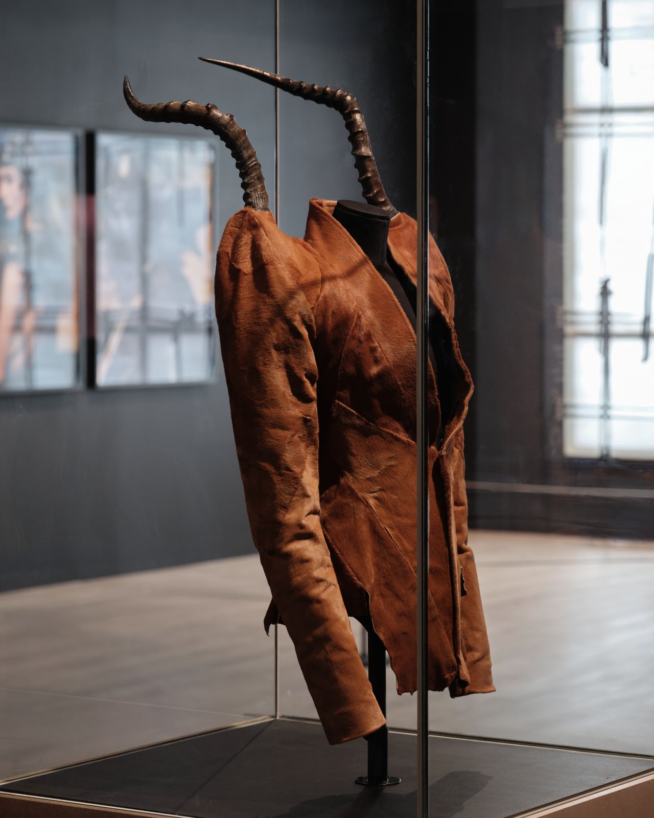Alexander McQueen's horn-shouldered jacket from the Autumn Winter 1997 It's a Jungle Out There collection displayed in a museum case
