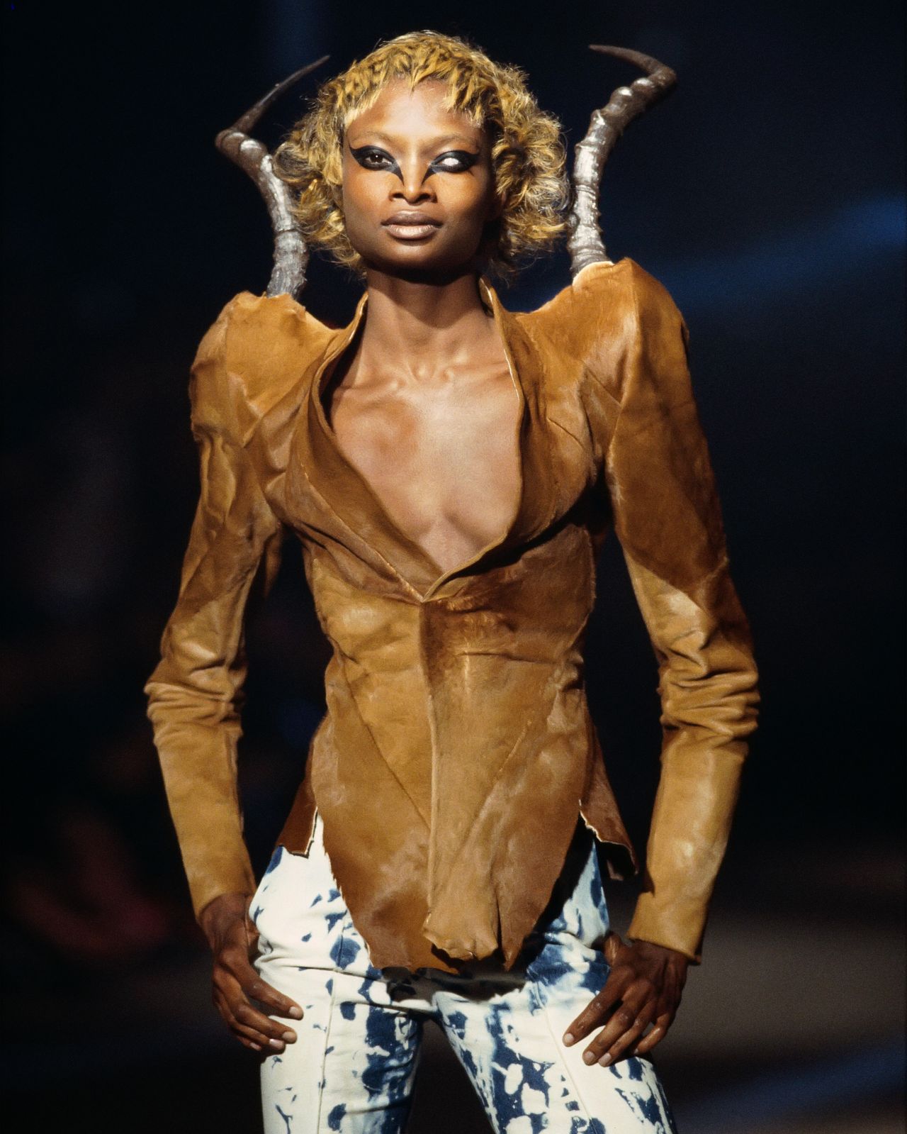 Archival Alexander McQueen runway image showing a model in a horn-shouldered jacket from Autumn Winter 1997