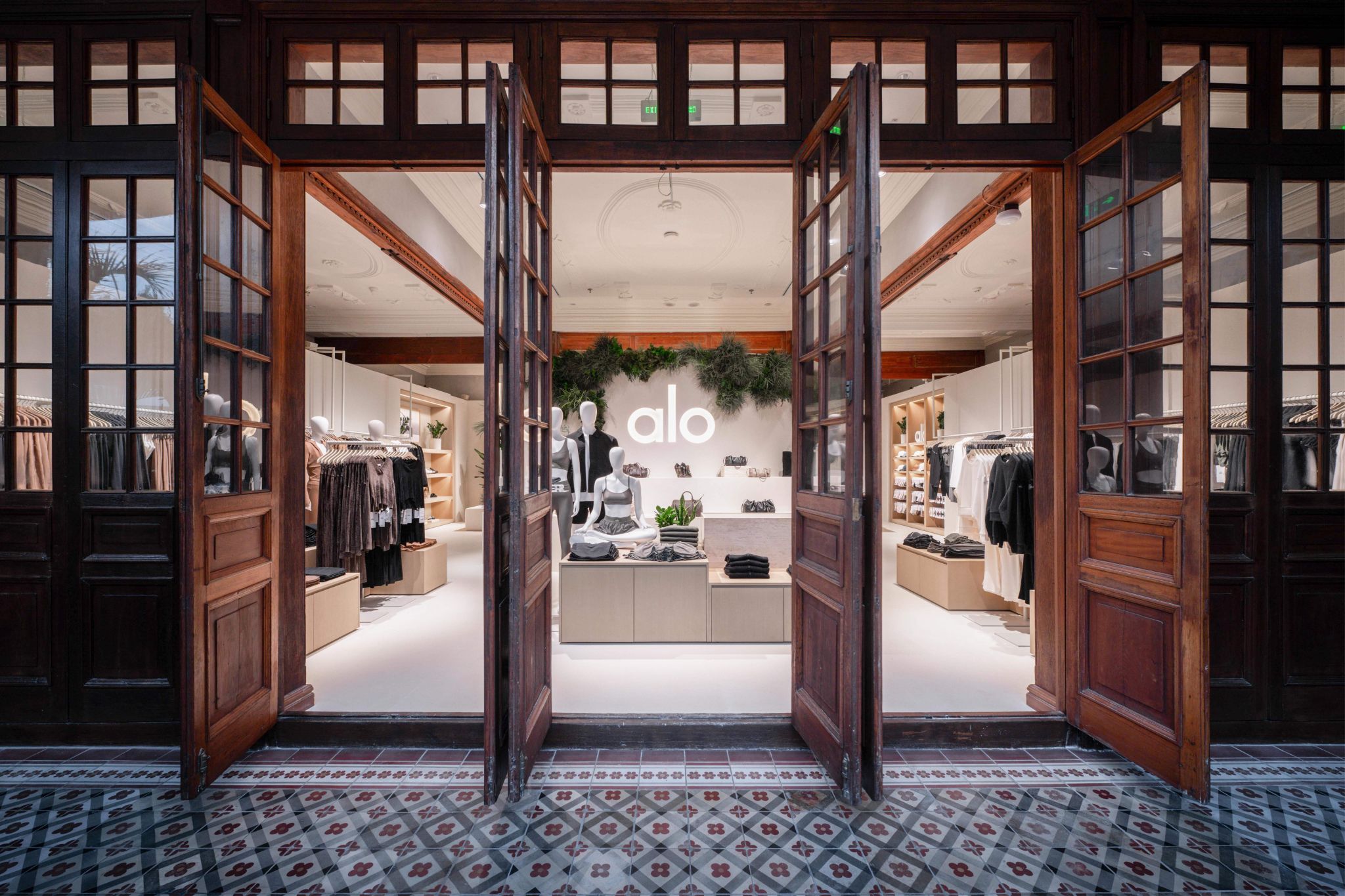 Open wooden doors leading into the Alo retail space