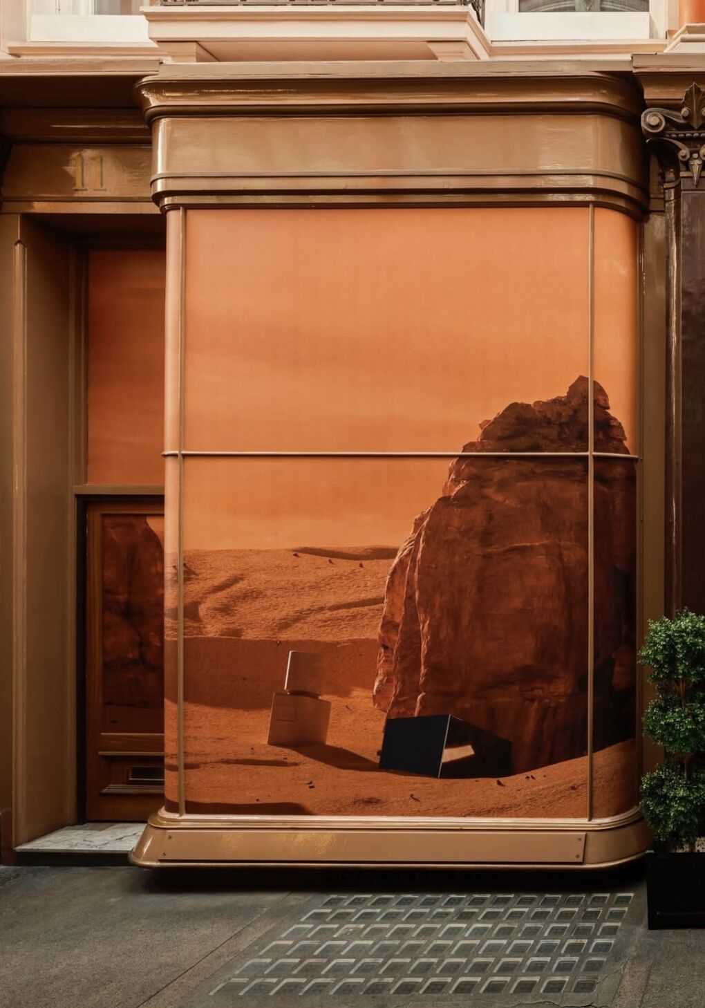 Desert landscape imagery wrapping a curved Amouage window