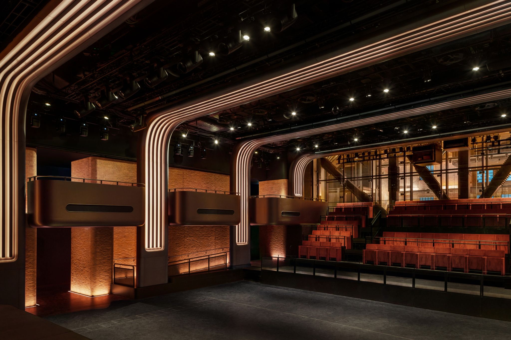 Side view of Apple Music Hall's illuminated arches and tiered seating