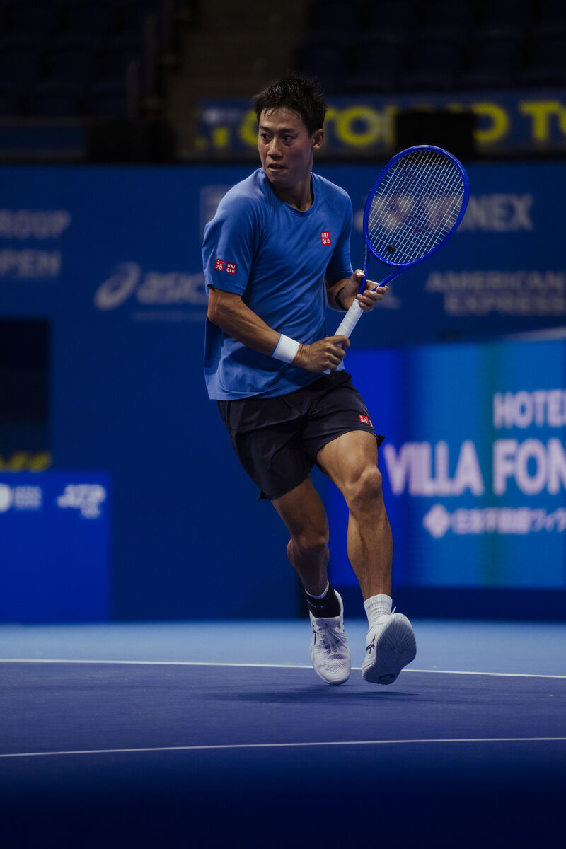 Archival on-court photograph of Kei Nishikori supplied with ASICS advisory announcement