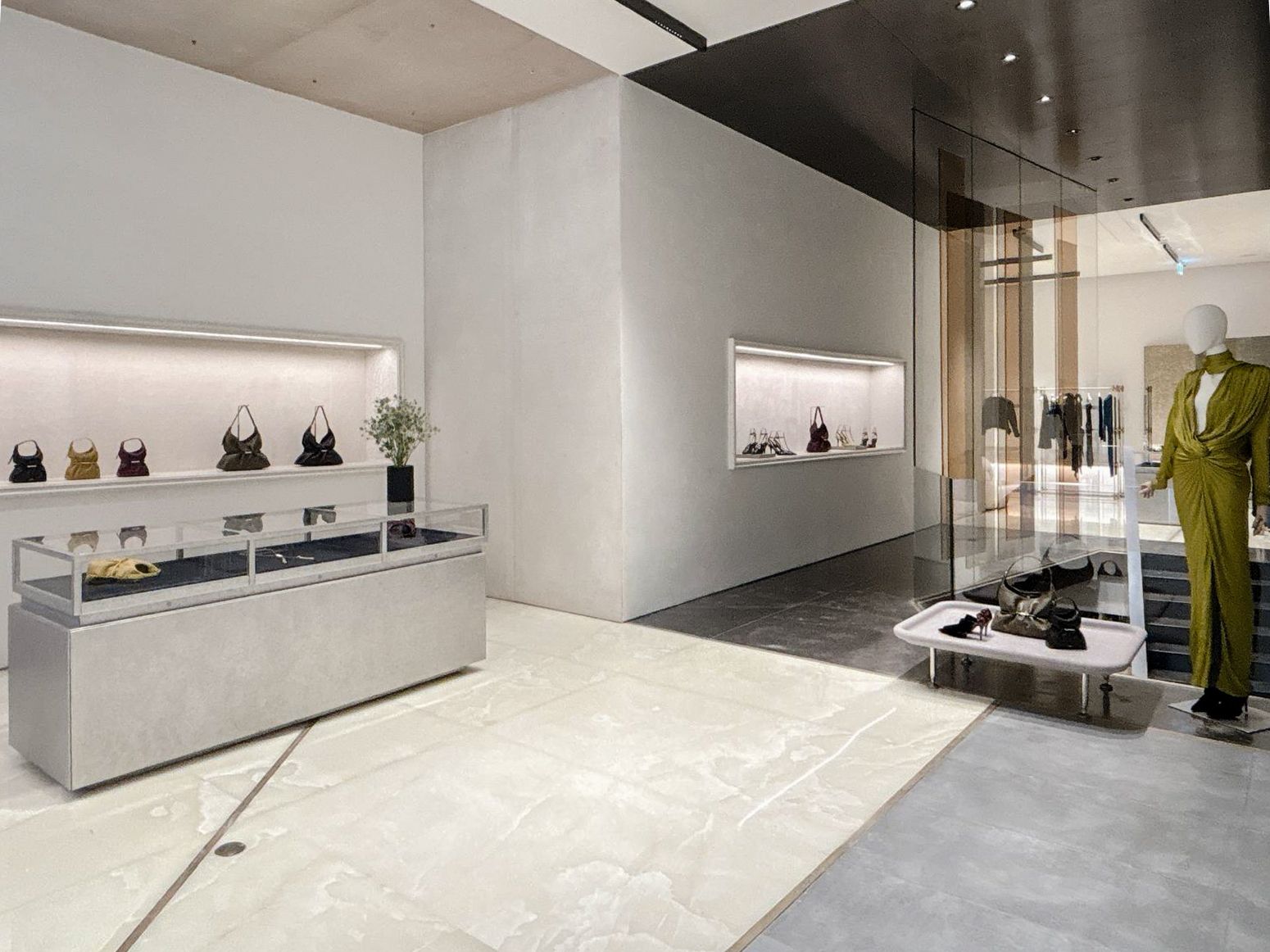 Interior of Balmain’s Milan flagship with glass display cases and illuminated handbag shelves