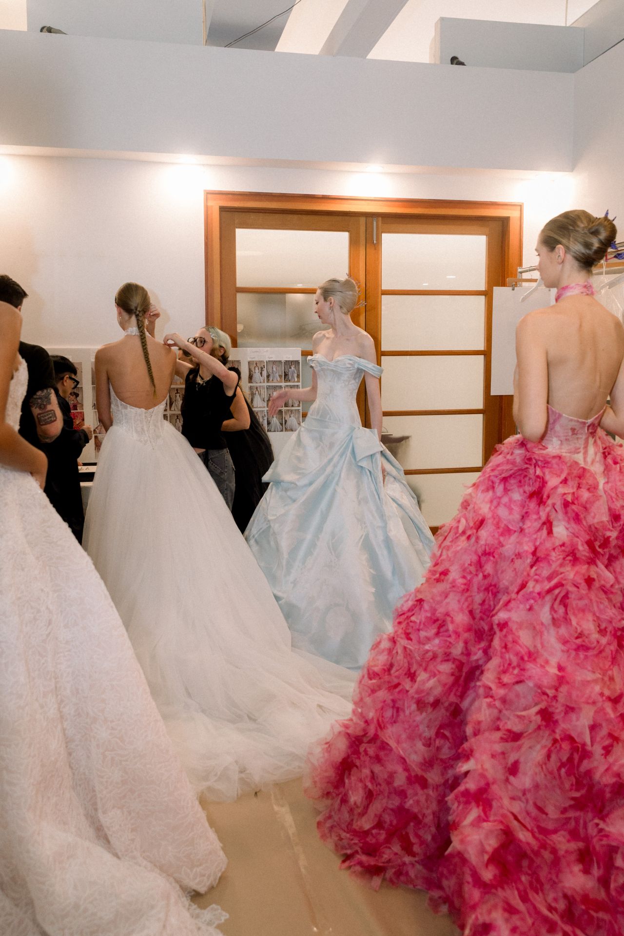 Bridal gowns and a pink feathered look backstage