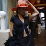 Guest wearing a coral Borsalino hat at the Spring/Summer 2027 presentation
