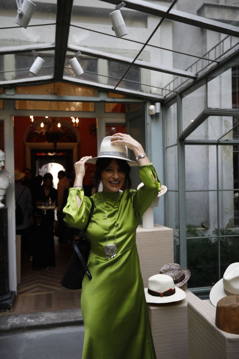 Guest trying on a white Borsalino hat at the Spring/Summer 2027 presentation