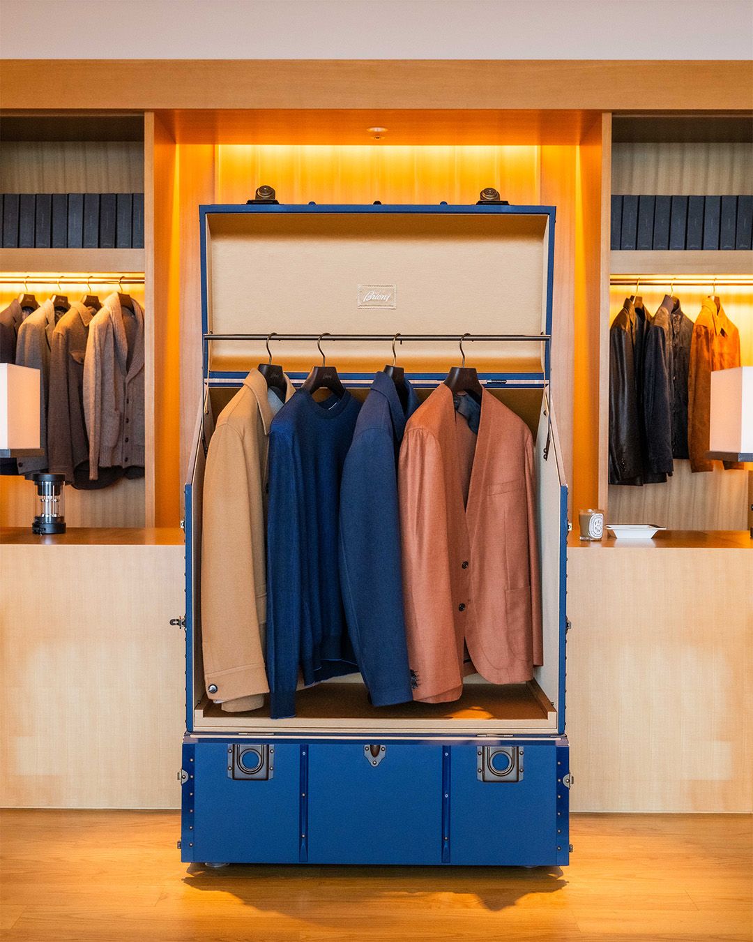 Brioni garments presented in a blue travel trunk at the Tokyo event
