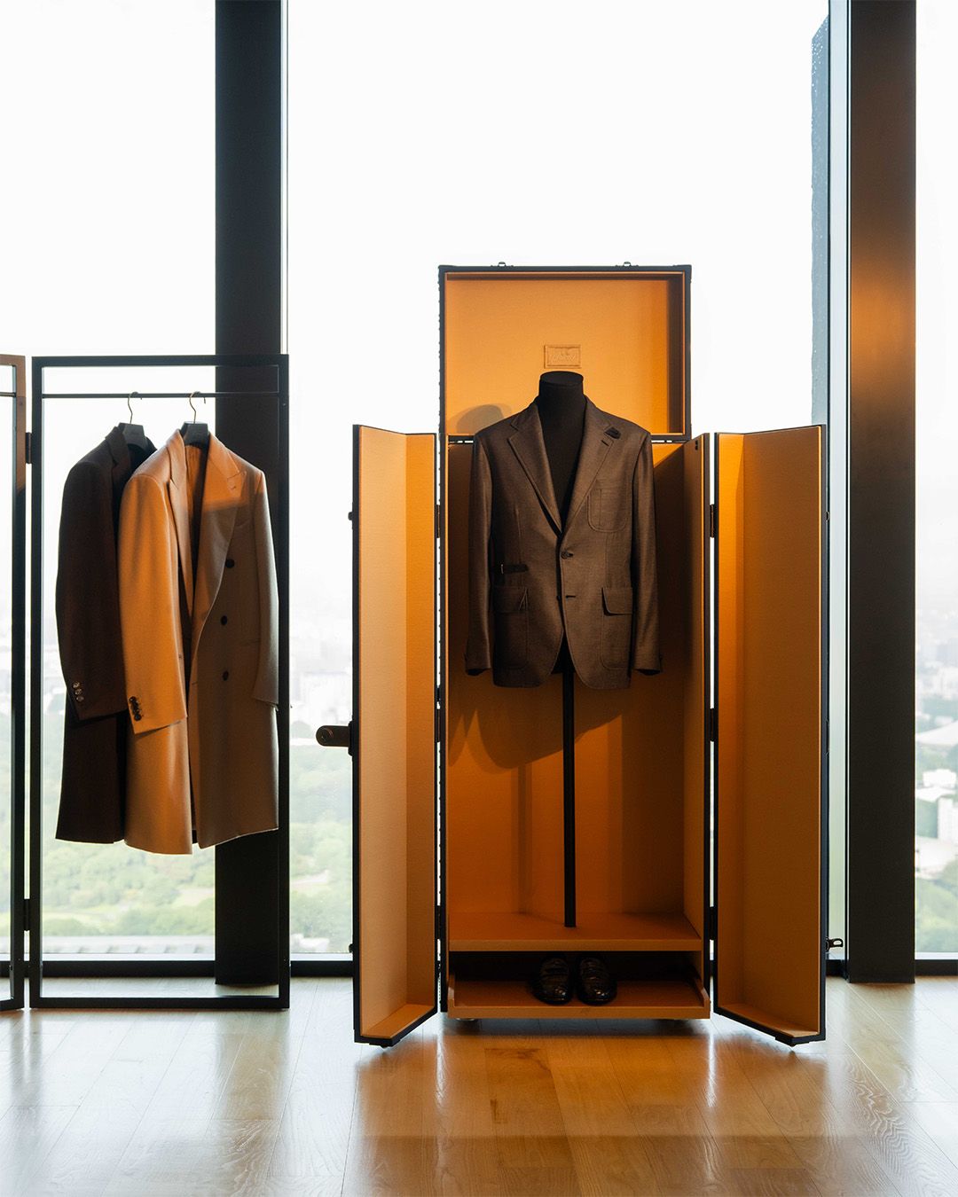 Tailored Brioni jackets displayed beside an open presentation trunk