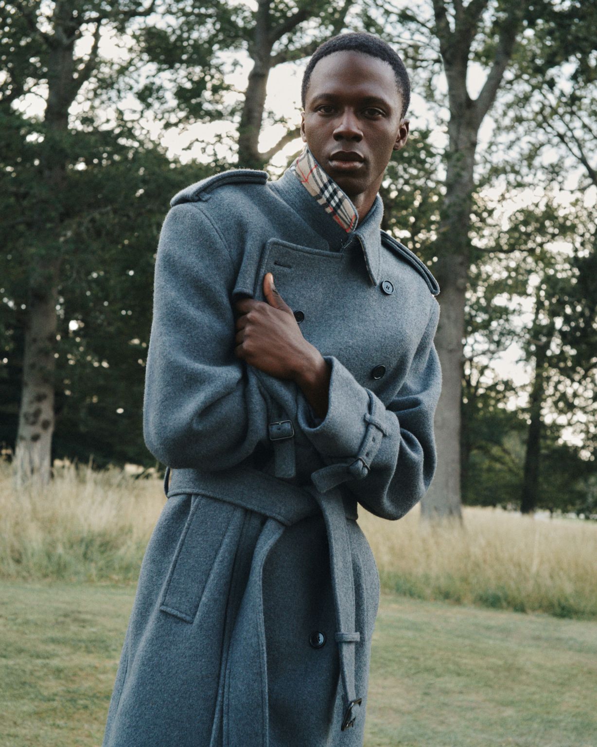 Model wearing a gray belted Burberry coat outdoors