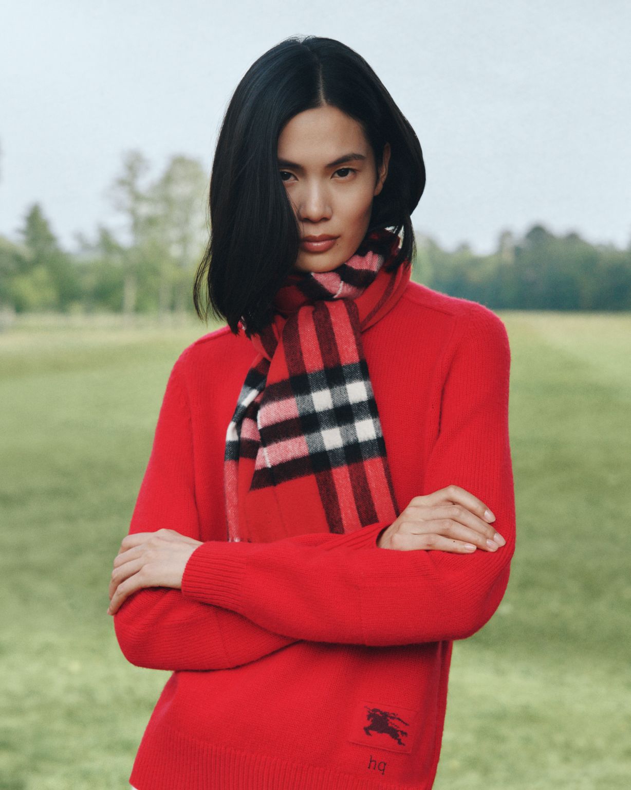 Model wearing red Burberry knitwear and a Check scarf