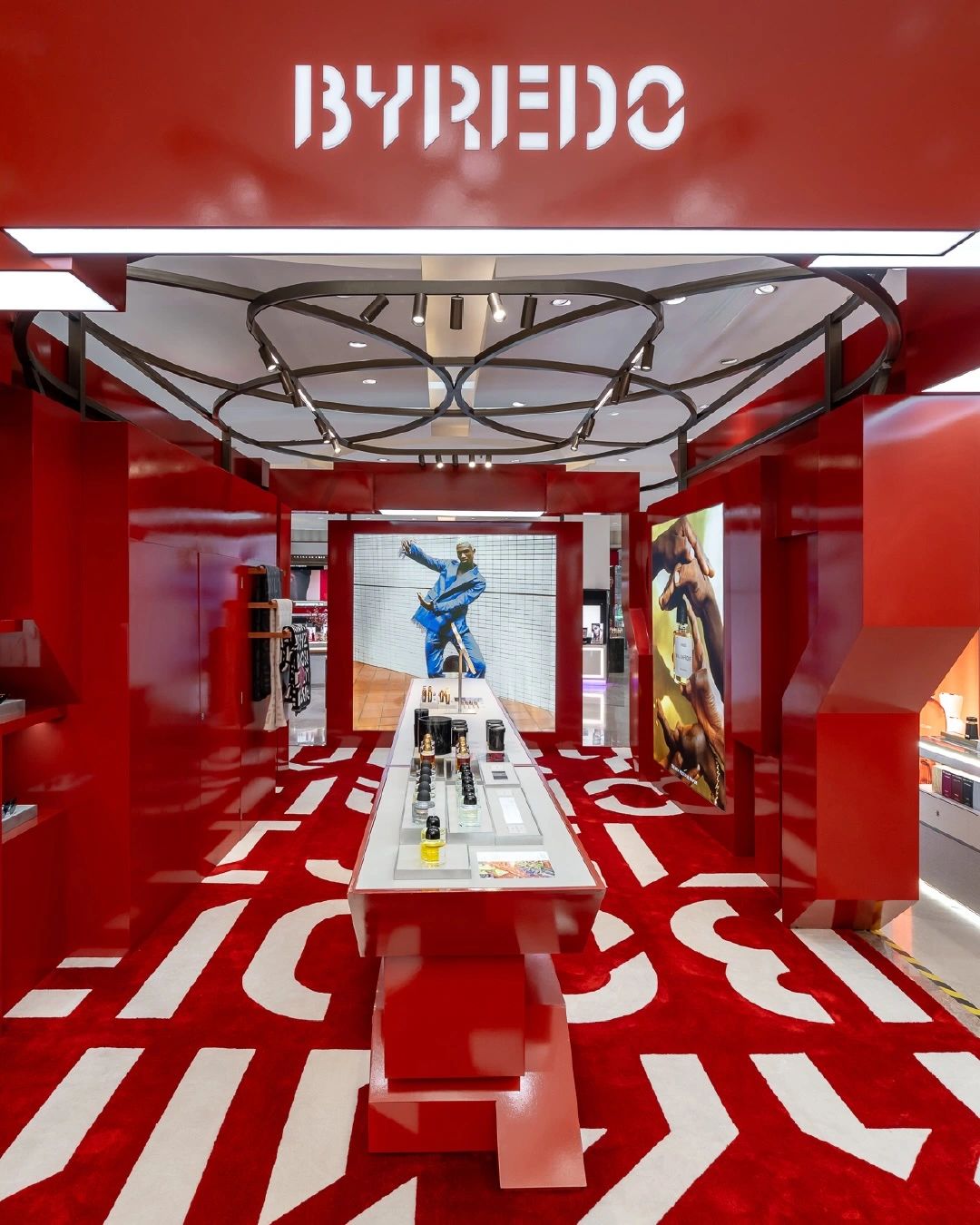 Red Byredo retail installation with fragrance displays, photograph 1