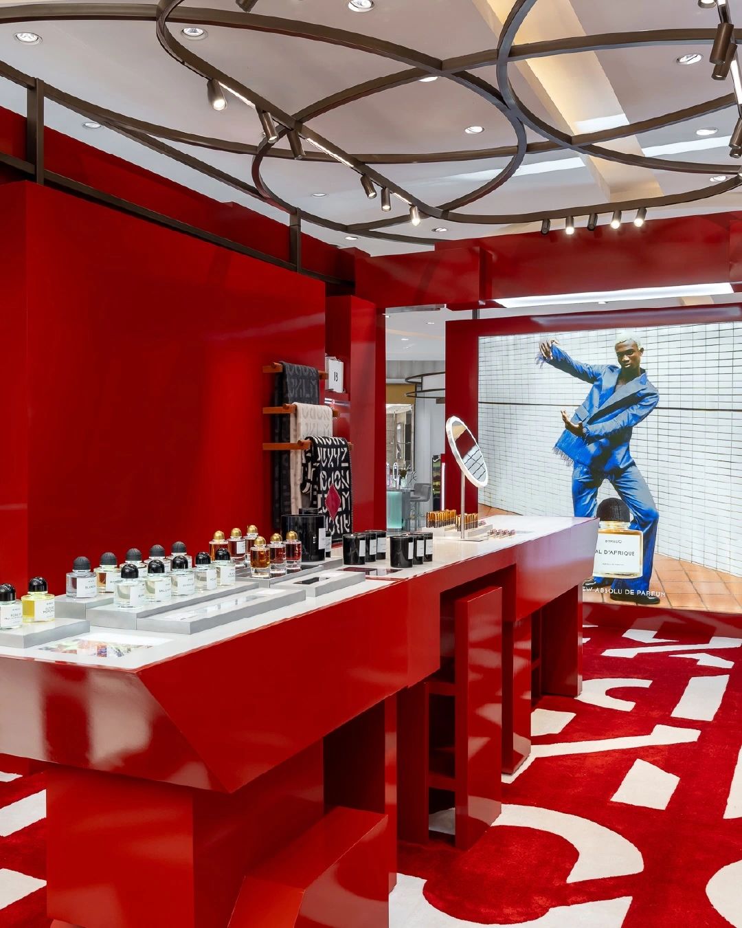 Red Byredo retail installation with fragrance displays, photograph 3