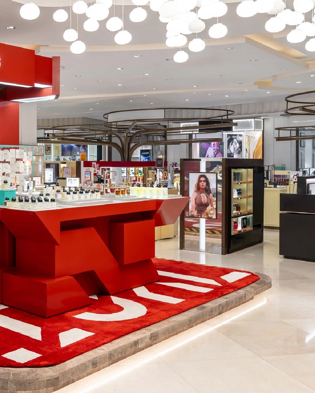 Red Byredo retail installation with fragrance displays, photograph 5