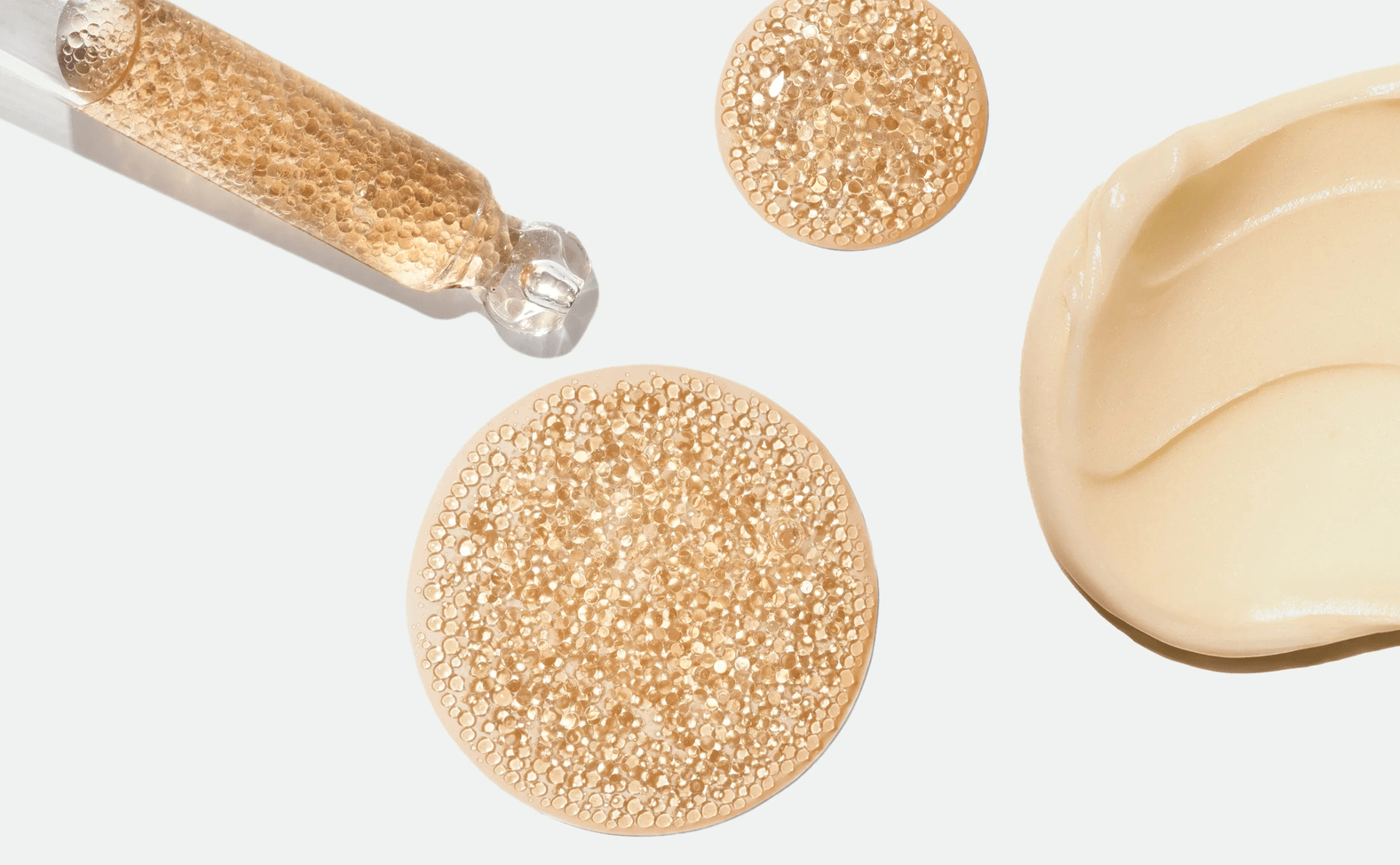 Golden encapsulated droplets and a white cosmetic cream texture shown in Capsum imagery.
