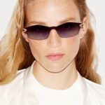 Model wears tinted Cartier eyewear with panther-head accents at the hinges
