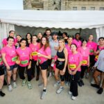 Celine employees pose together in pink Odysséa event shirts