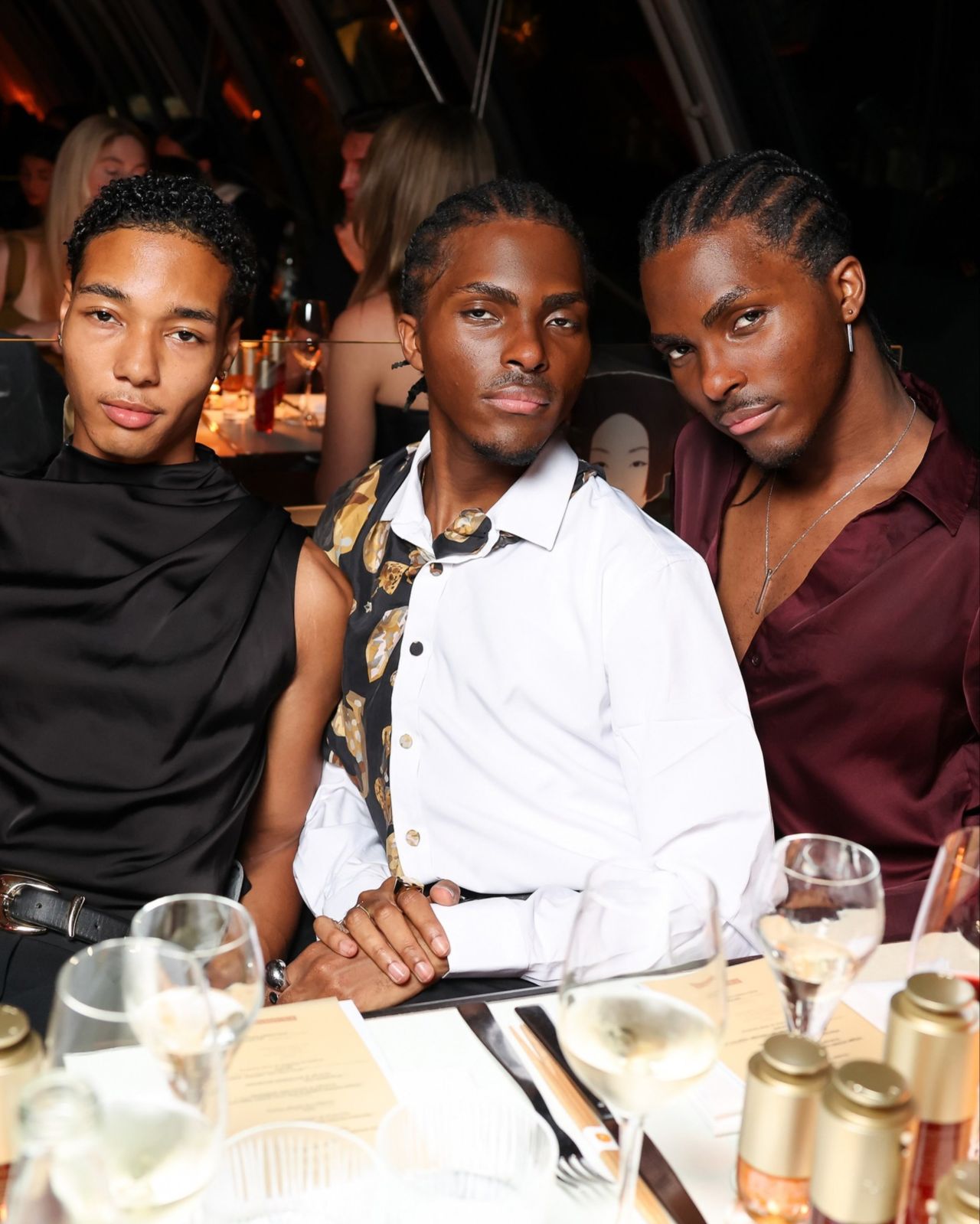 Three guests seated at the Clarins Fashion Week dinner