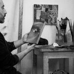 Alain Urrutia holding an artwork in his studio.