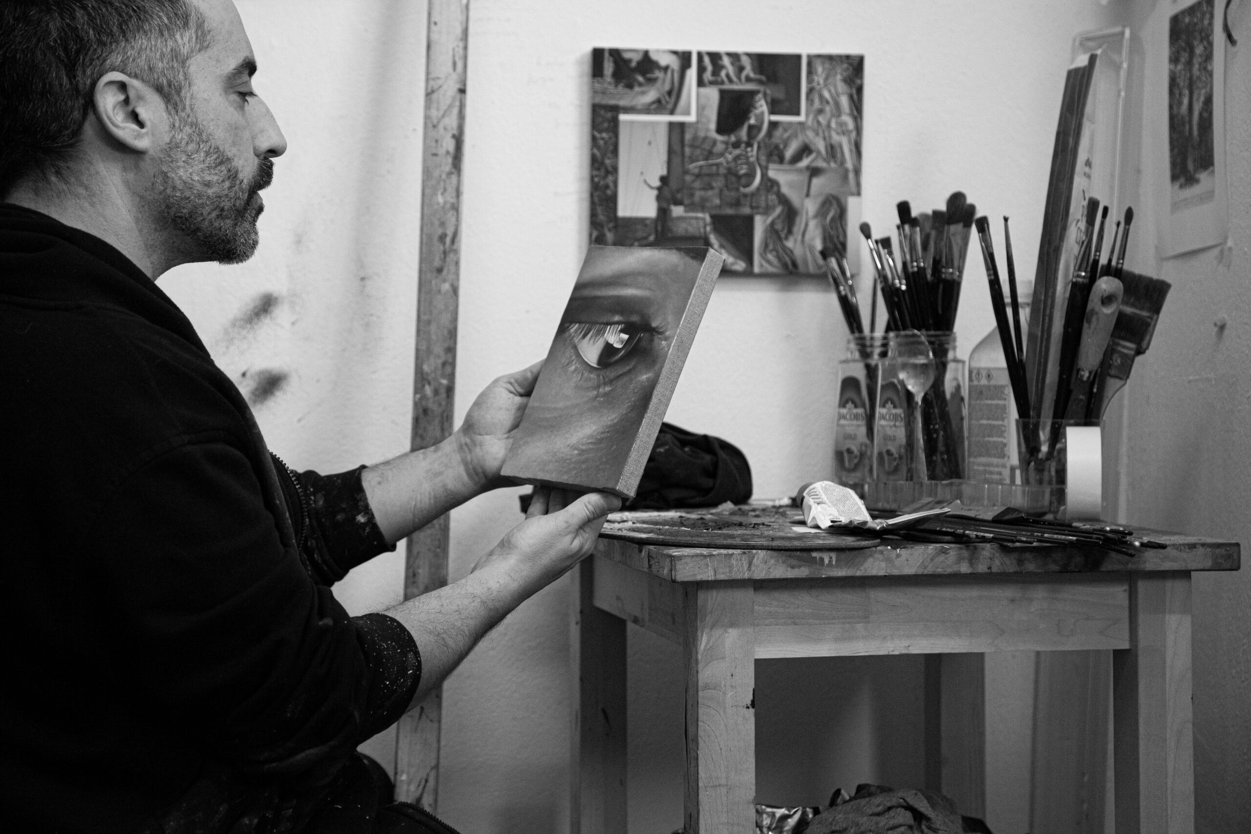 Alain Urrutia holding an artwork in his studio.
