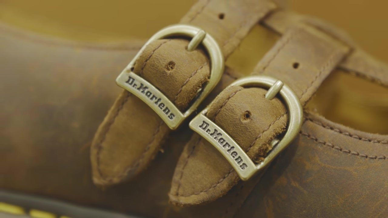 Close view of Dr. Martens branded buckles on brown footwear