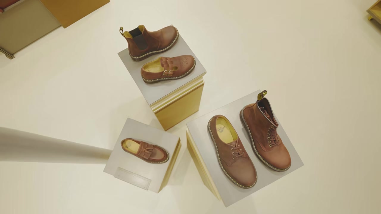 Brown Dr. Martens boots and loafers displayed on plinths in Le Marais