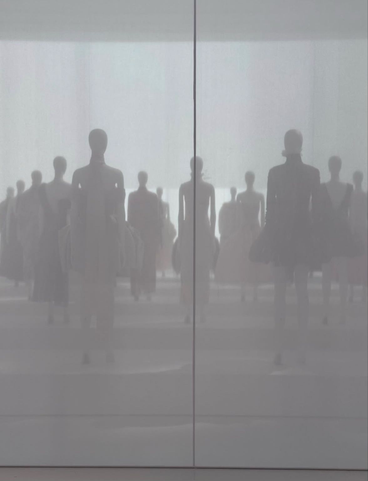 Silhouettes of exhibition mannequins behind a translucent screen