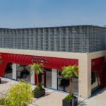 Exterior of Ferrari's Riyadh showroom with red facade and palm trees