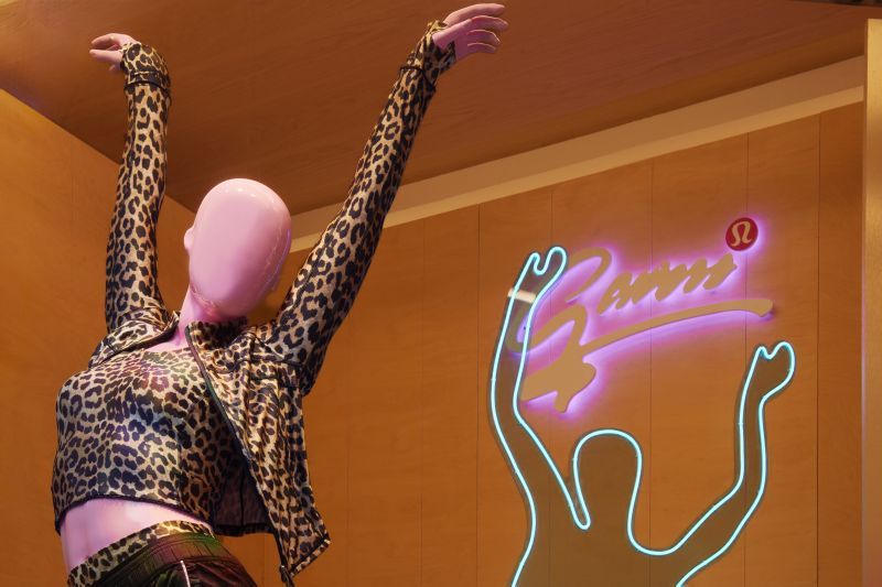 GANNI x lululemon window mannequin with raised arms and neon dance silhouette