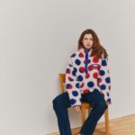 Model in red-and-blue dotted Gap x Whitney sherpa pullover inspired by Roy Lichtenstein