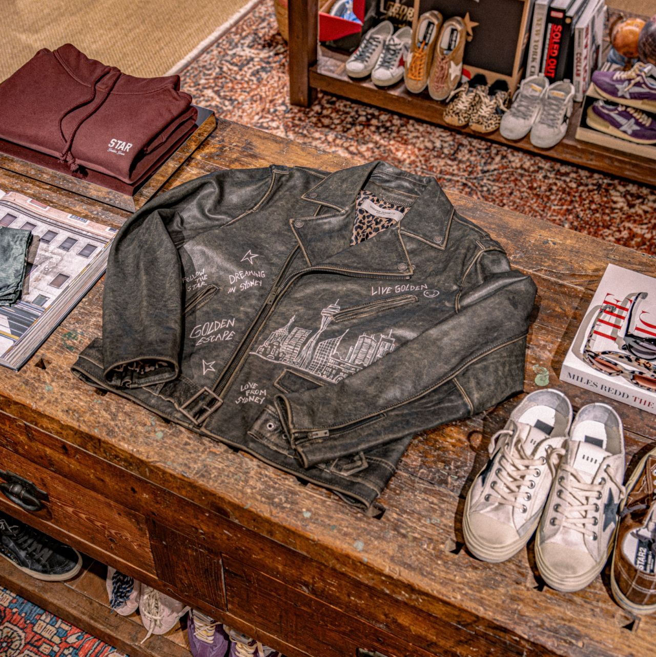 Golden Goose apparel, footwear and accessories arranged on a display table
