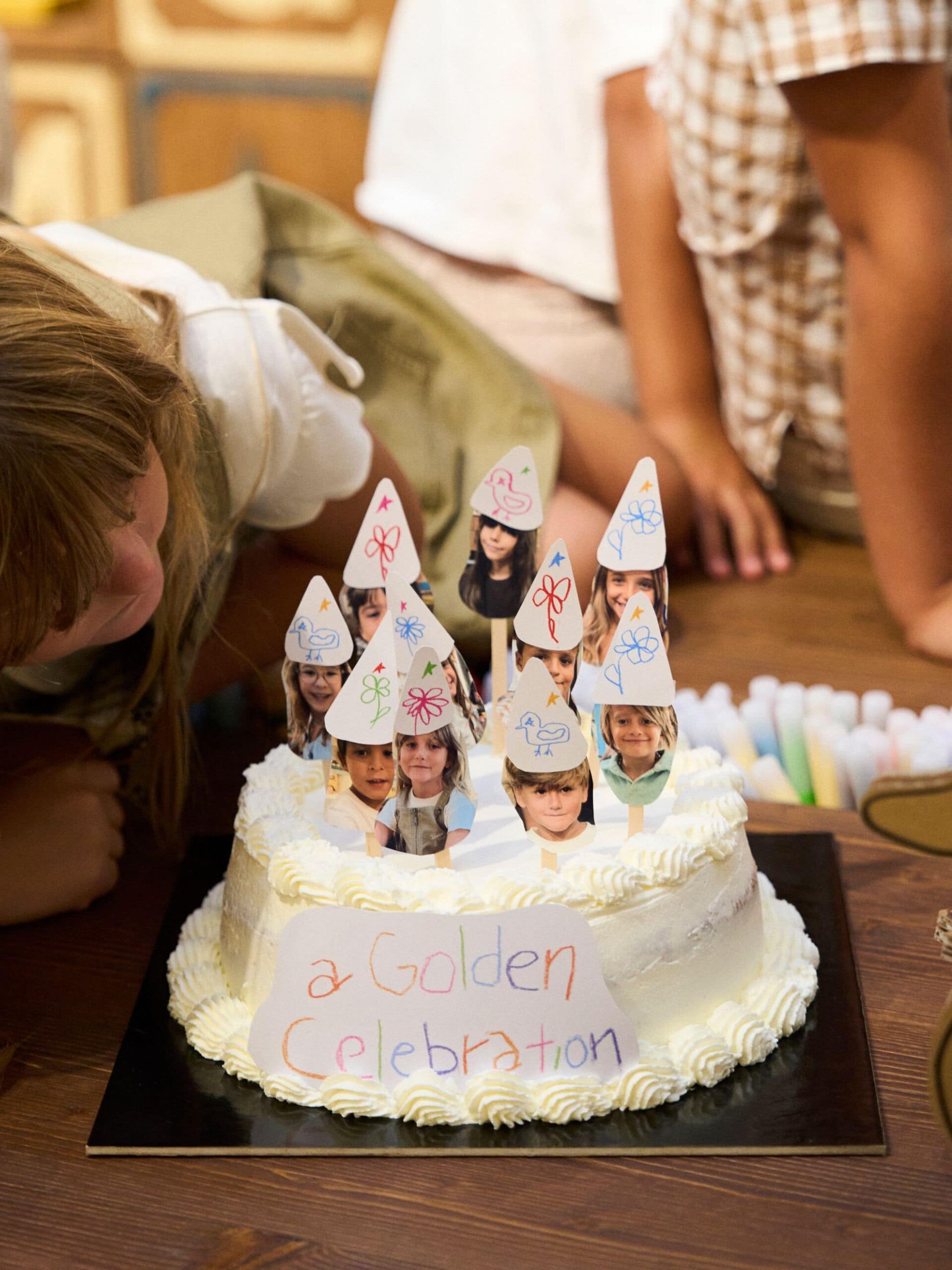 Golden Celebration cake decorated with children's portraits at the Rome Kids event