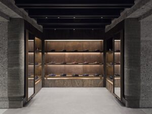 Loafers displayed on illuminated shelves between stone columns at Gucci’s Paris flagship