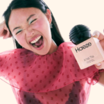 Model holding a bottle of Haeze fragrance in the brand’s Target launch campaign.