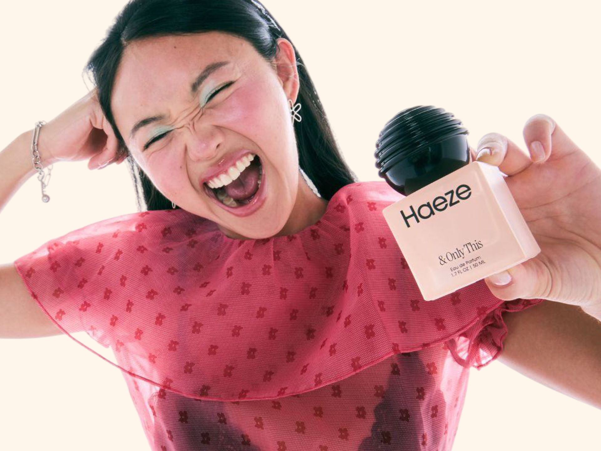 Model holding a bottle of Haeze fragrance in the brand’s Target launch campaign.