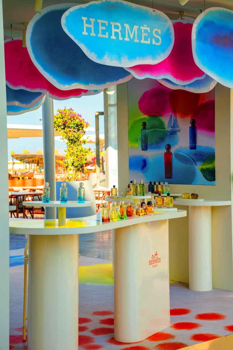 Hermès scent bottles displayed beneath the podium’s colorful canopy