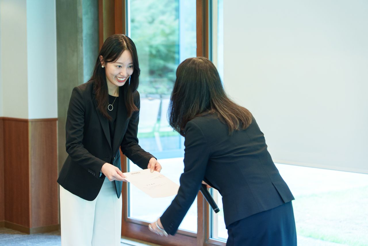 Participants exchange a document during the Hermès Japan welcome ceremony