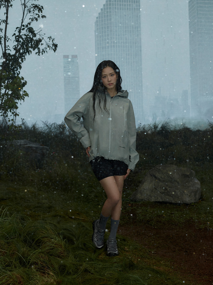 JISOO wears weather-ready Salomon outerwear in a misty outdoor campaign image