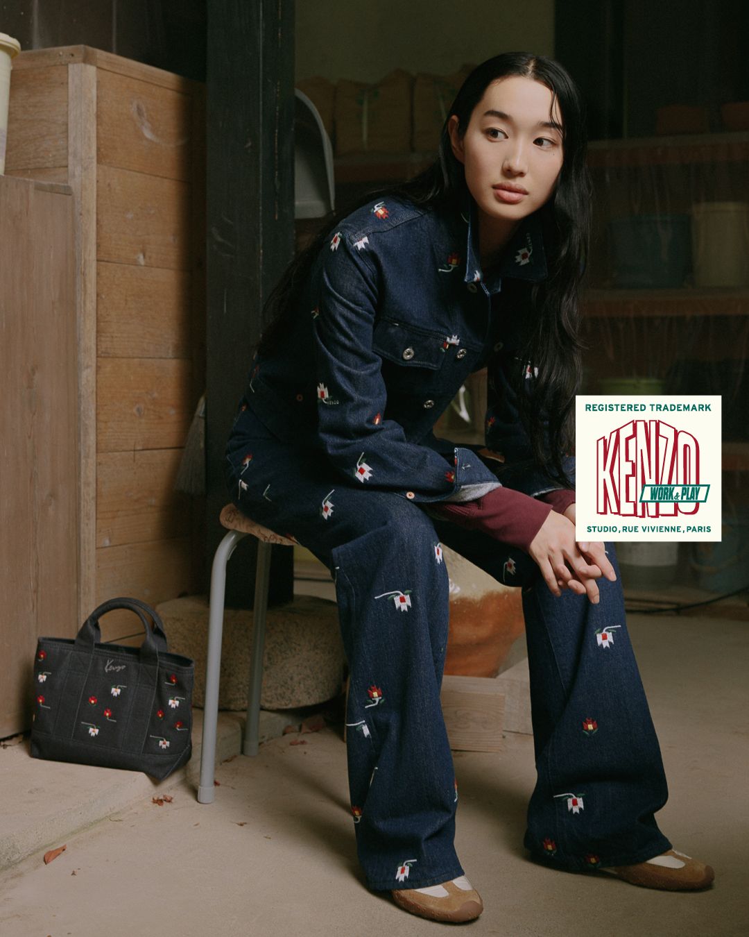 Model in embroidered KENZO denim beside a matching bag