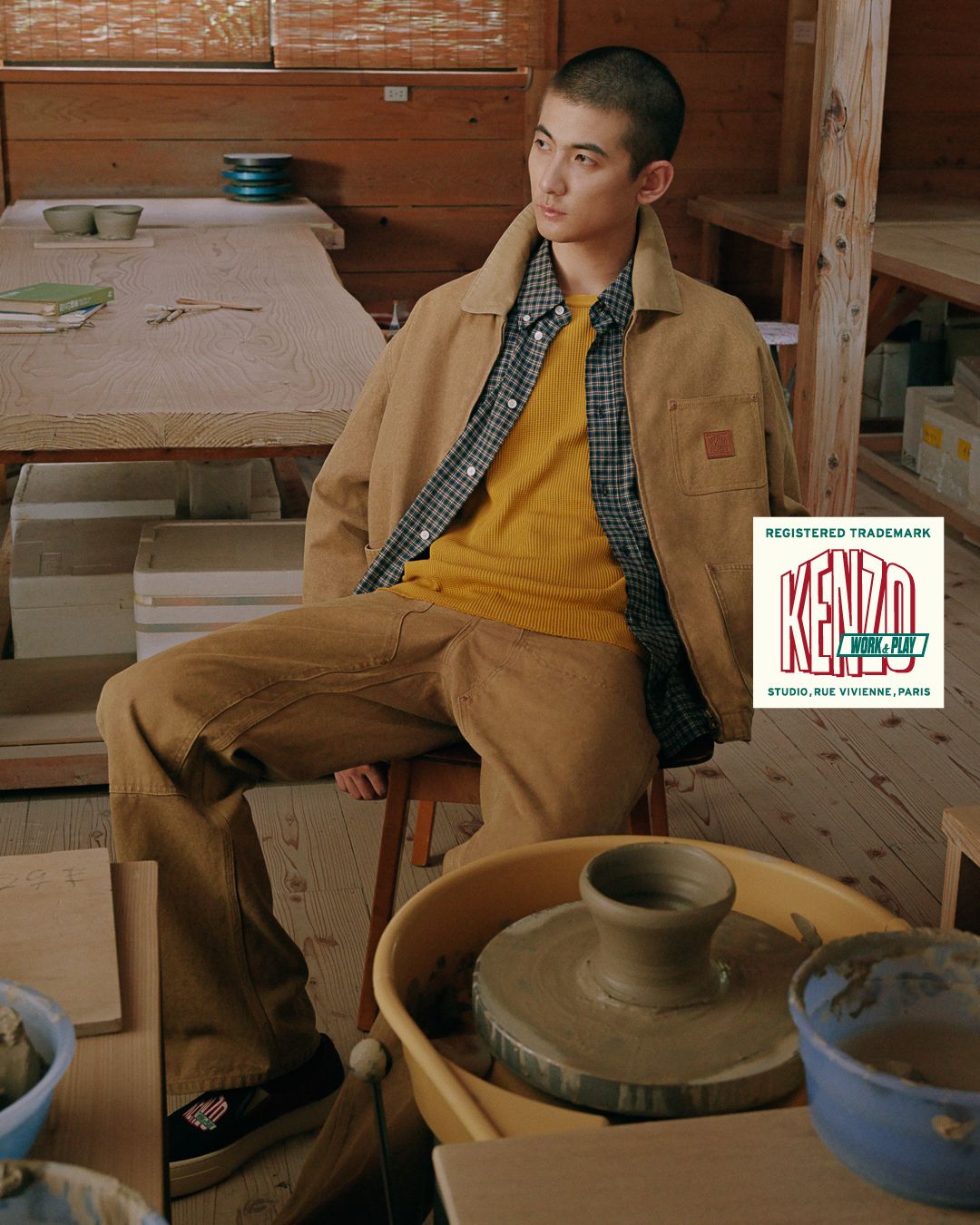 Model in tan KENZO workwear beside a pottery wheel