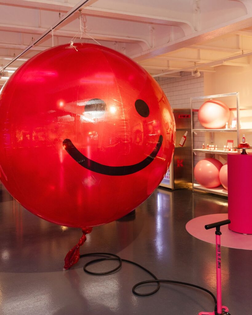 Oversized red smiley-face balloon inside Kiehl’s London Plump Club pop-up