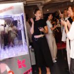 Visitors beside a Kiehl’s branded claw machine at the London Plump Club