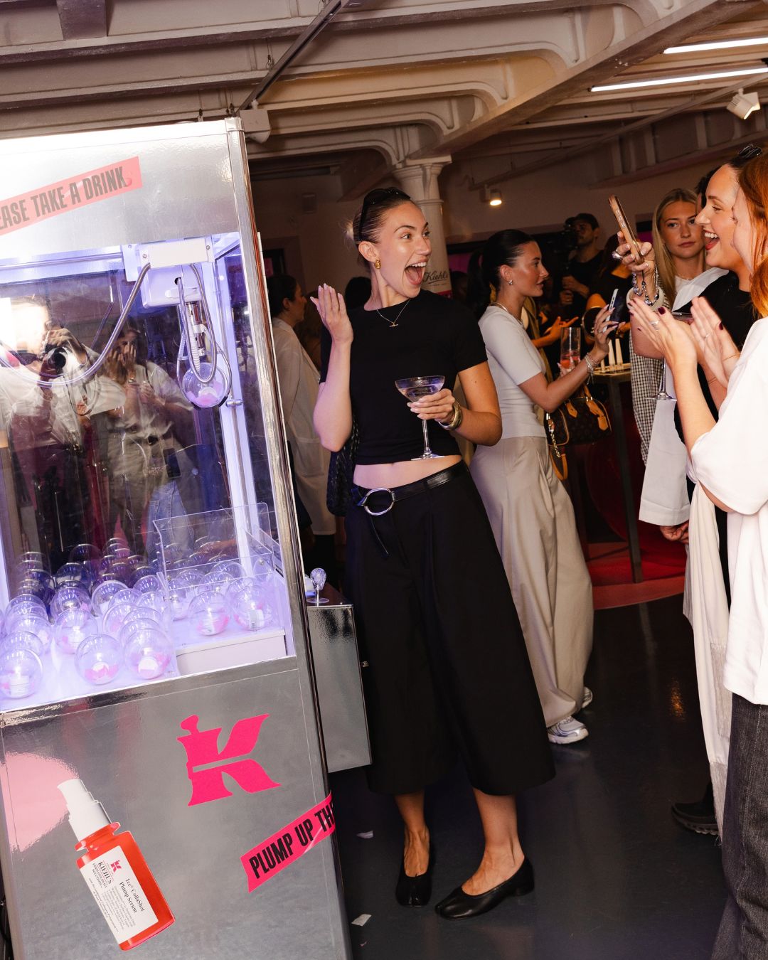 Visitors beside a Kiehl’s branded claw machine at the London Plump Club