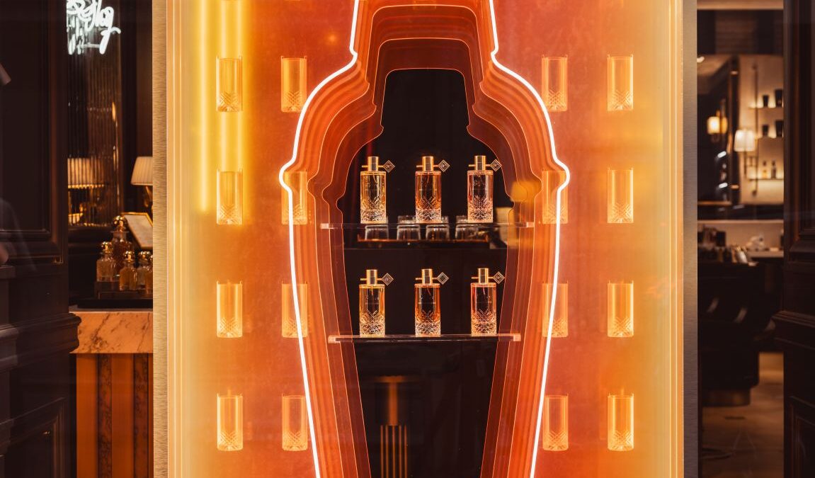 Orange illuminated bottle-shaped Kilian Paris window for The Cocktails