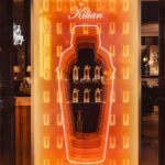Orange illuminated bottle-shaped Kilian Paris window for The Cocktails