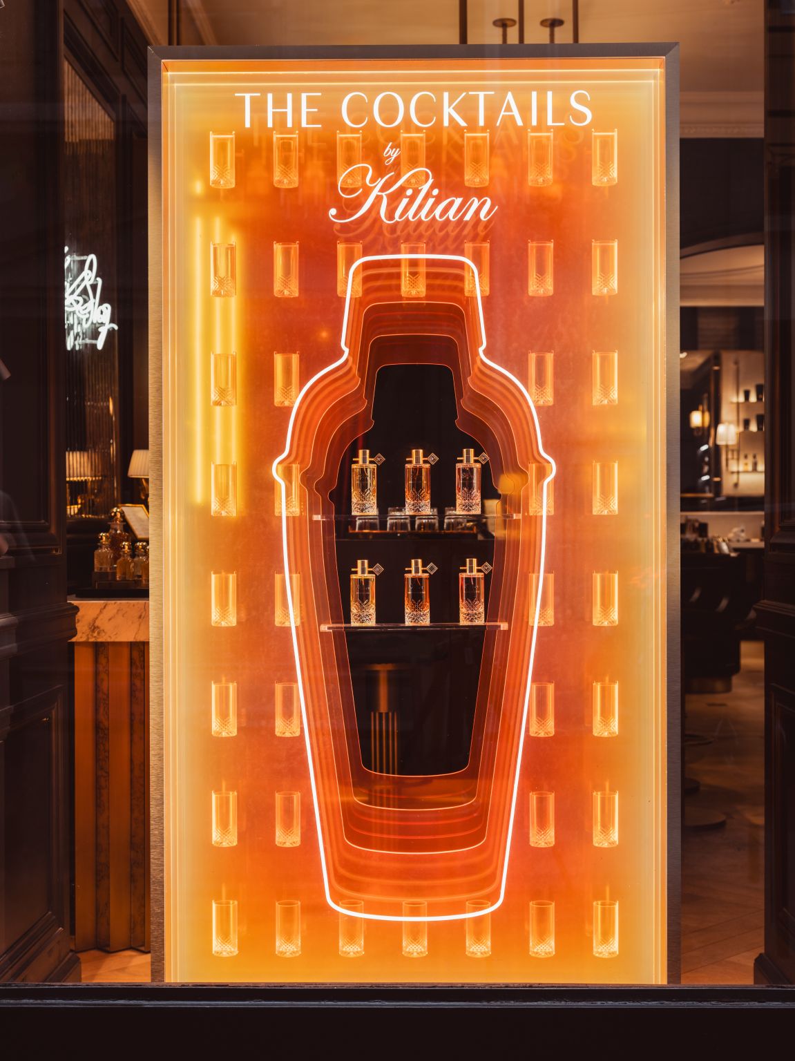 Orange illuminated bottle-shaped Kilian Paris window for The Cocktails
