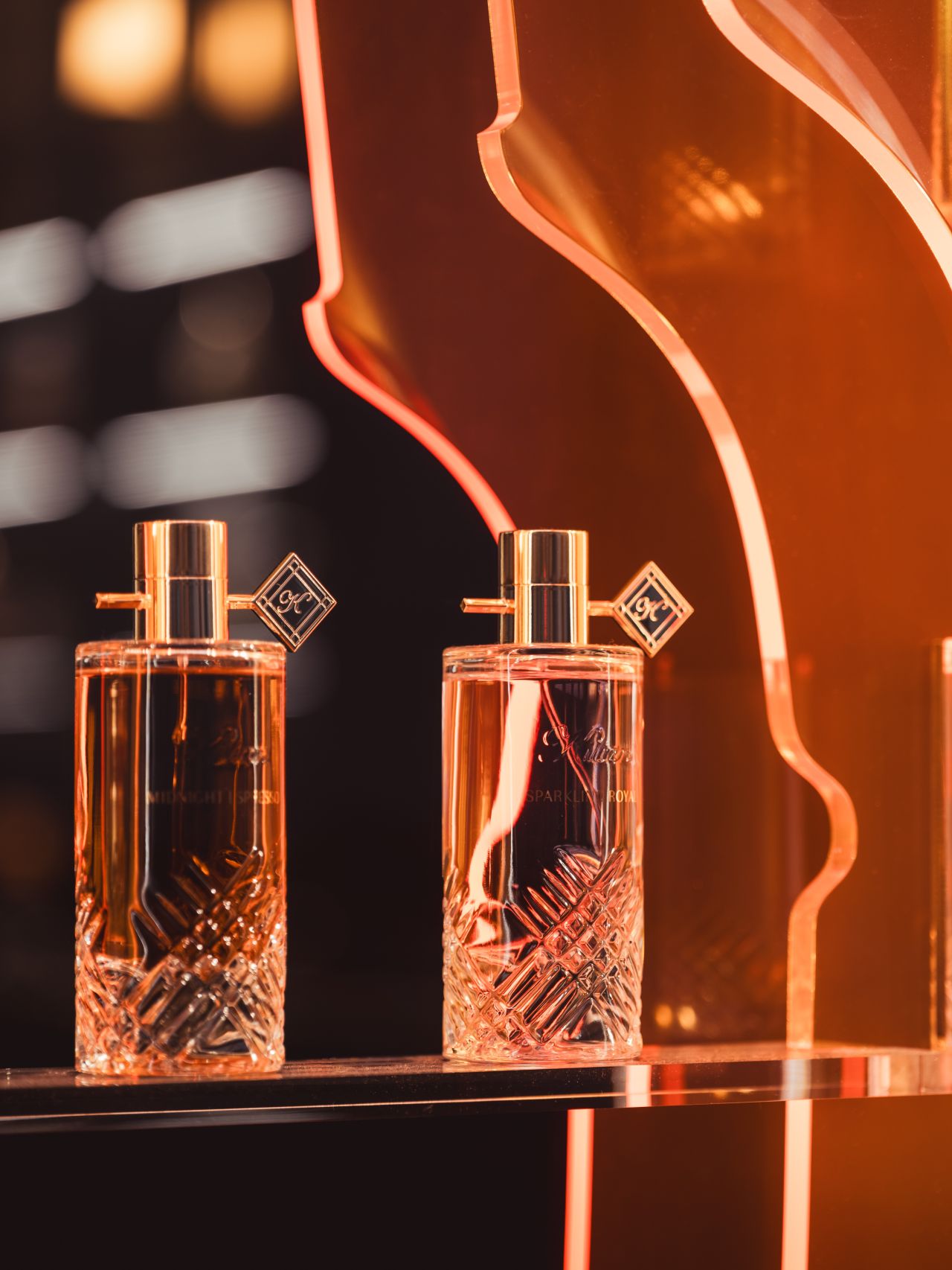 Two fragrance bottles within the illuminated window installation